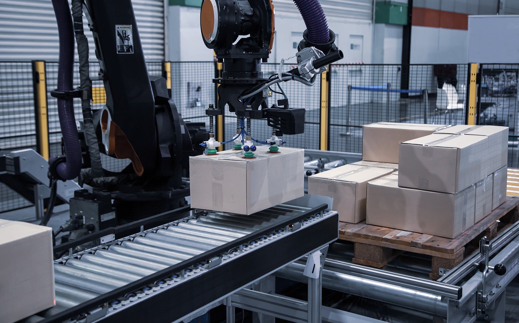 robotic arm moving box from conveyor onto pallet