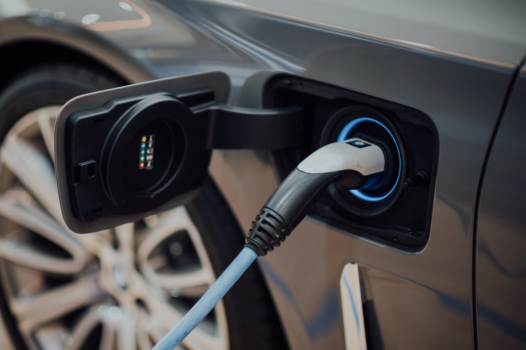 side view of electric car with charging port plugged in