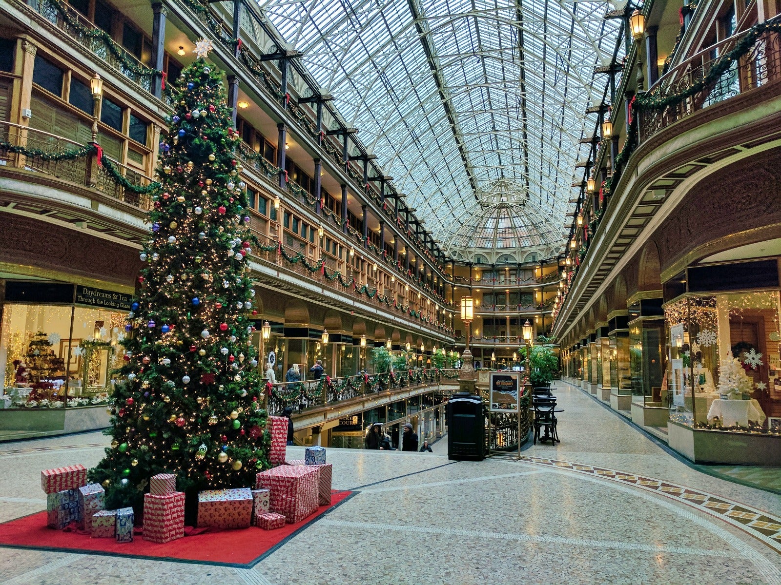 interior of mall at christmastime with large christmas tree in foreground and decorations throughout